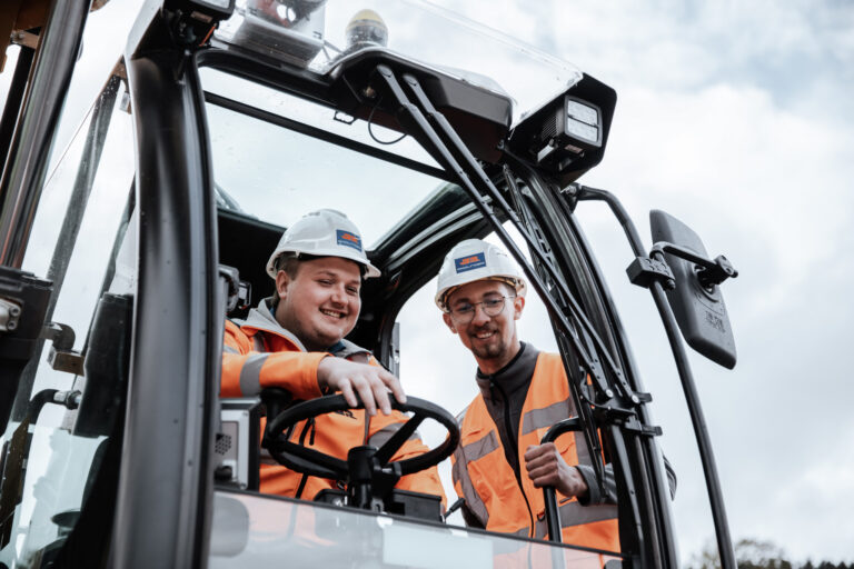 2 Bauarbeiter auf einem Bagger